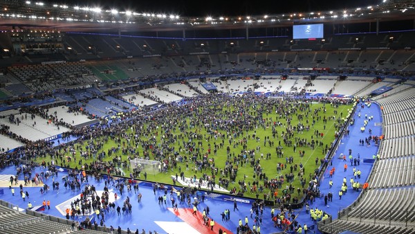 Spectators invade the pitch of the Stade de France stadium after the international friendly soccer France against Germany, Friday, Nov. 13, 2015 in Saint Denis, outside Paris. At least 35 people were killed in shootings and explosions around Paris, many of them in a popular theater where patrons were taken hostage, police and medical officials said Friday. Two explosions were heard outside the Stade de France stadium. (AP Photo/Michel Euler)